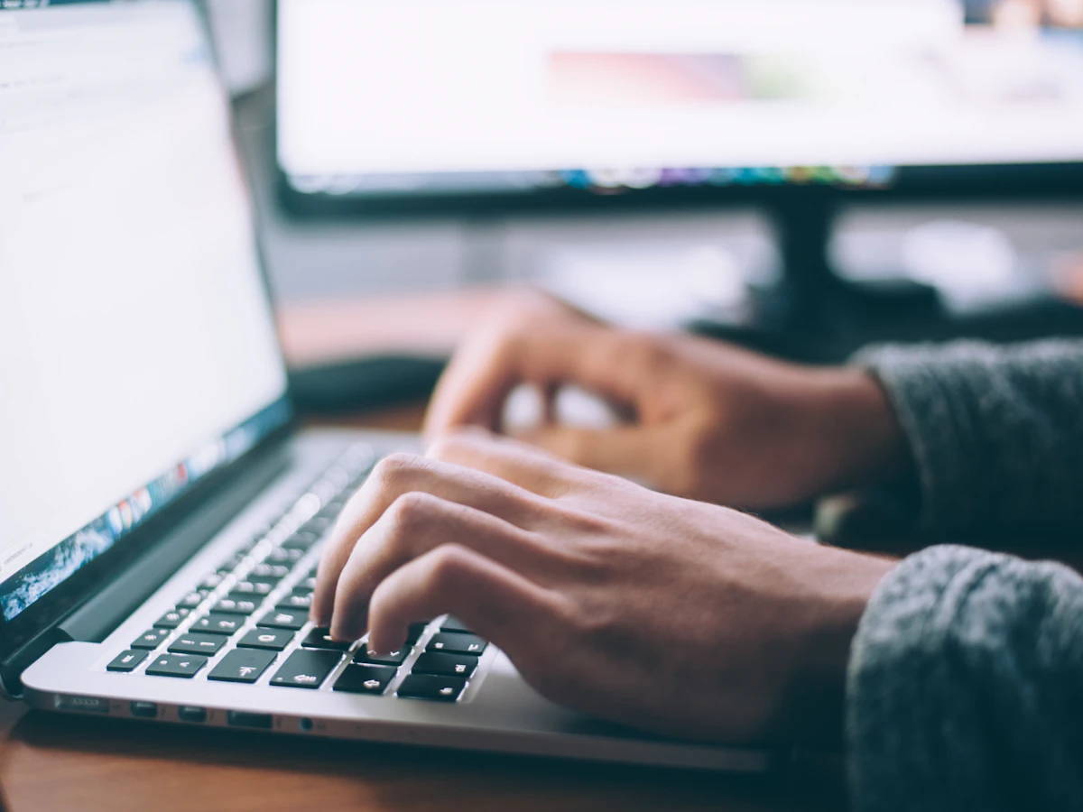 Hands typing an email on a laptop